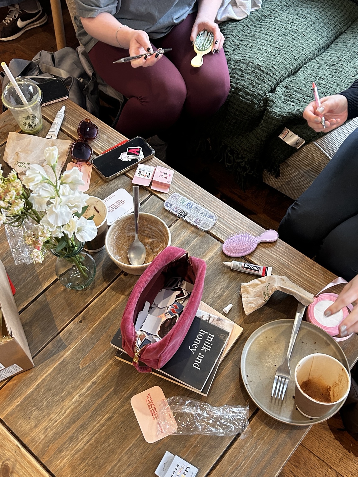 A shared table covered with flowers, stationery and creative materials