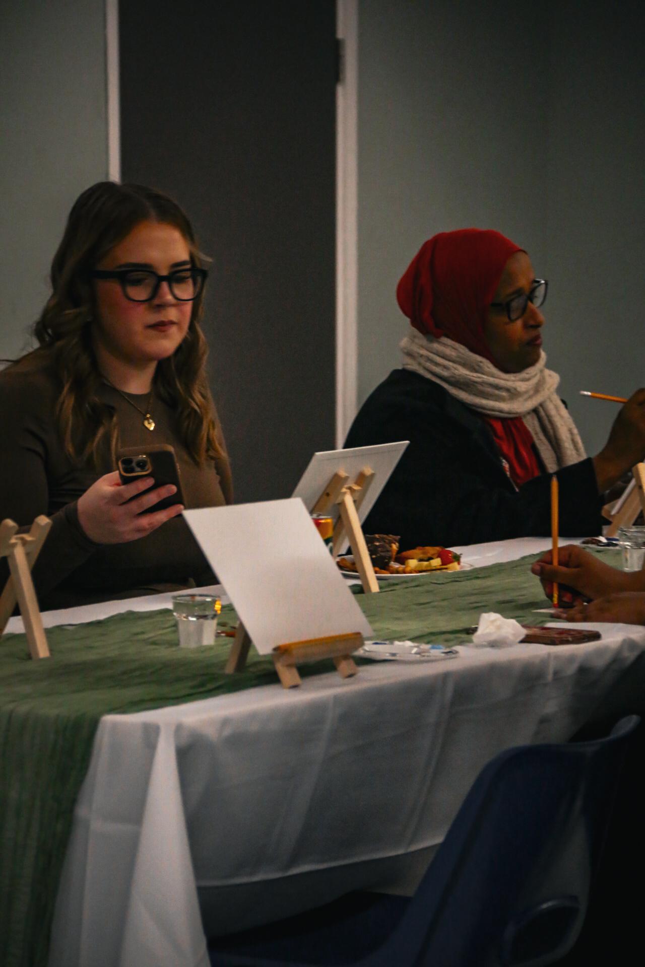 Women sitting together at a paint workshop